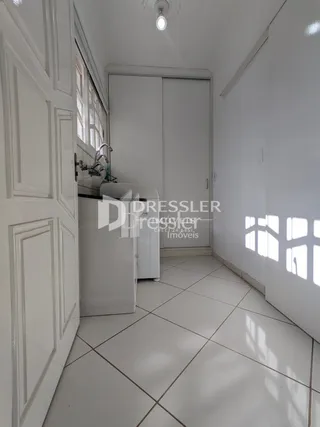Hall de entrada com piso branco e paredes brancas.