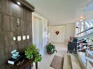 Foto de uma área de sala com painel de madeira escura na entrada de uma residência.