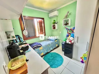 Quarto com cama e ar condicionado em um ambiente de cores claras.