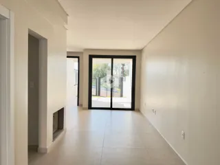 Hall de entrada de uma residência com piso claro e paredes brancas.