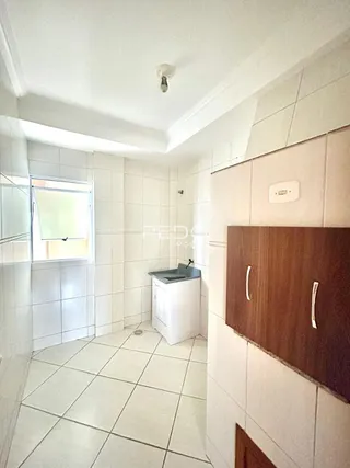 Corredor interno com piso de cerâmica e paredes brancas.