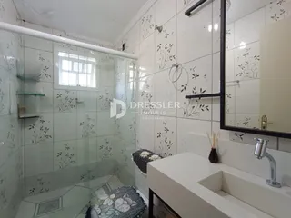 Banheiro com revestimento de azulejos brancos.