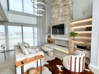 Sala de estar moderna com grandes janelas e lareira em um apartamento em Lajeado.