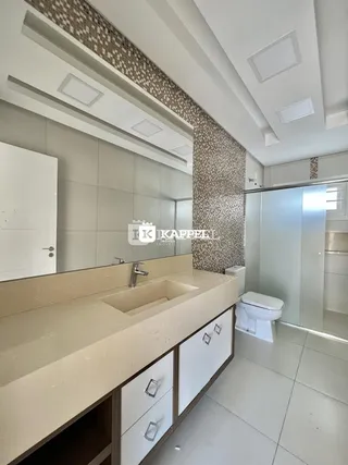 Cozinha com bancada clara e armários brancos em ambiente moderno.