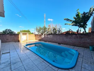 Piscina externa com piso de cerâmica em uma propriedade.