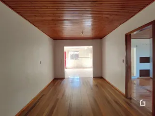 Corredor interno com piso de madeira e teto de madeira.