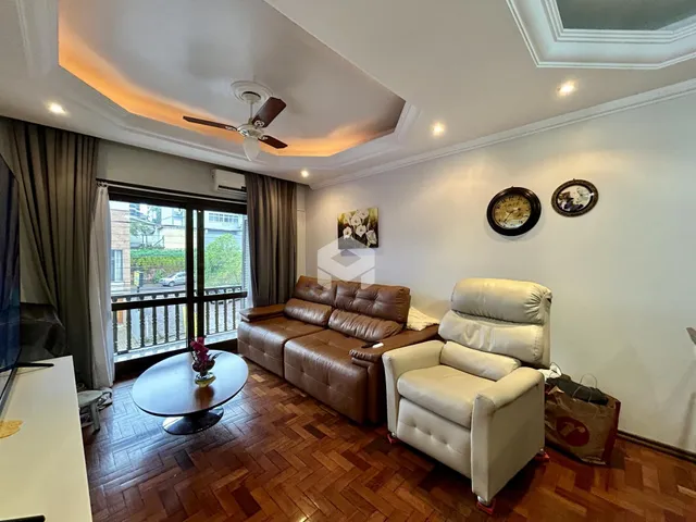 Sala de estar com piso de madeira e vista para o exterior.