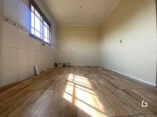 Foto de um ambiente interno com piso de madeira e janela.