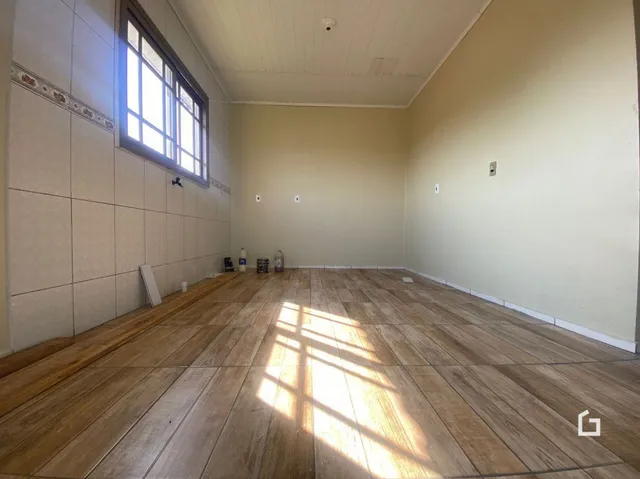 Foto de um ambiente interno com piso de madeira e janela.