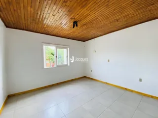 Ambiente interno com piso de cerâmica e teto de madeira clara.