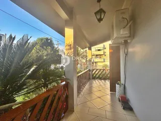 Corredor interno com vista para a área externa e vegetação.