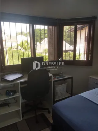 Quarto com janela e área de trabalho em imóvel no Lajeado.