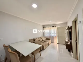 Sala de estar com mesa de jantar e sofá em um ambiente claro.