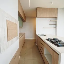 Vista de um ambiente interno com armários de madeira clara.