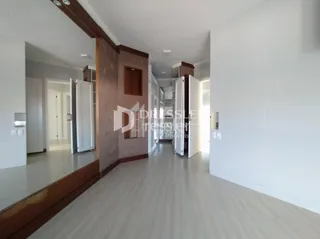 Corredor interno de uma residência com piso claro e detalhes em madeira.