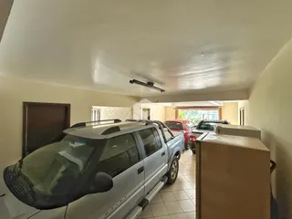 Vista interna de um corredor com uma caminhonete estacionada.