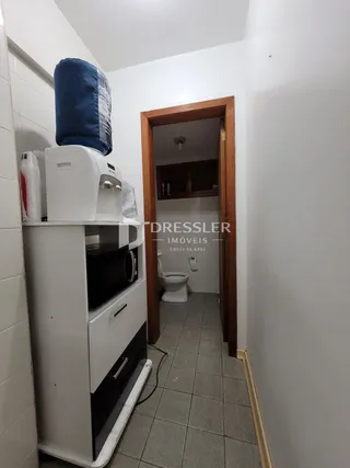 Vista de um corredor interno com porta de madeira.