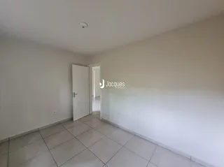 Interior de um ambiente com paredes brancas e piso de cerâmica.
