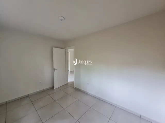Interior de um ambiente com paredes brancas e piso de cerâmica.