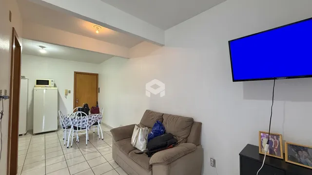 Sala de estar com sofá e televisão em um imóvel no Brasil.