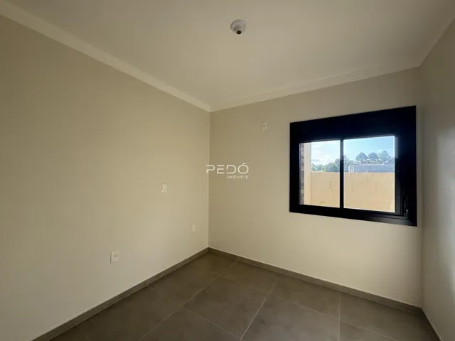 Vista interna de um ambiente com paredes claras e piso de cerâmica.