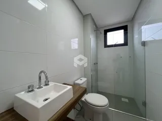 Foto de um banheiro com azulejos brancos e box de vidro.
