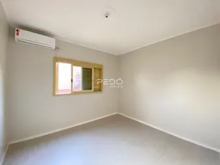 Ambiente interno de uma sala com paredes brancas e piso claro.