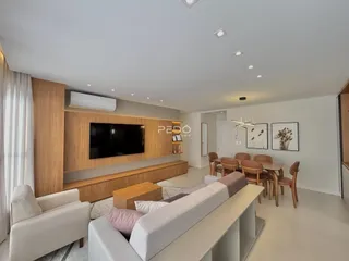 Sala de estar moderna com sofá e área de jantar em um apartamento.