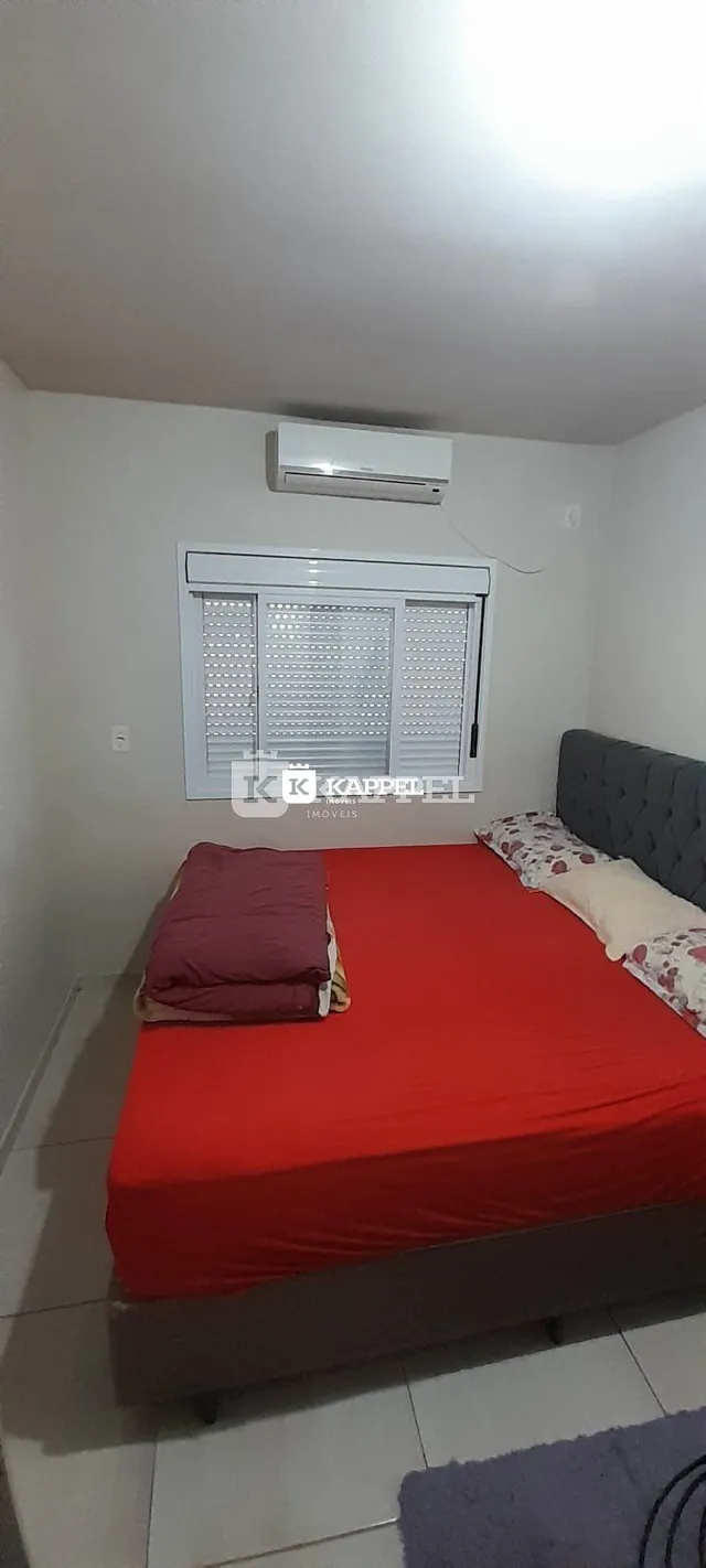 Quarto com cama de casal e janela com persianas brancas.