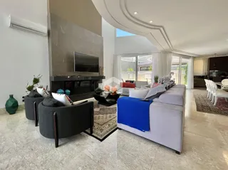 Sala de estar moderna com lareira e grandes janelas.
