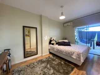 Quarto com cama e espelho em ambiente interno.