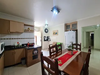 Ambiente de sala de jantar e cozinha em um imóvel no Brasil.