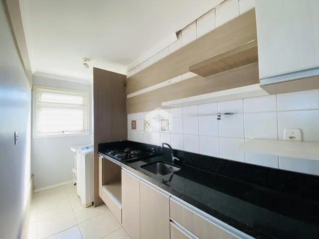 Interior de uma cozinha com armários e bancada escura.