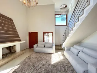 Sala de estar com lareira e escadaria em ambiente residencial.