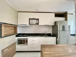 Foto de uma cozinha moderna com armários brancos e bancadas escuras.