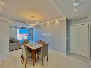 Sala de estar e jantar com sofá e mesa de jantar em um apartamento.