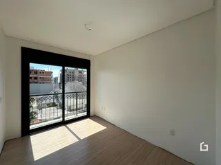 A sala de estar possui piso de madeira clara e grandes janelas.