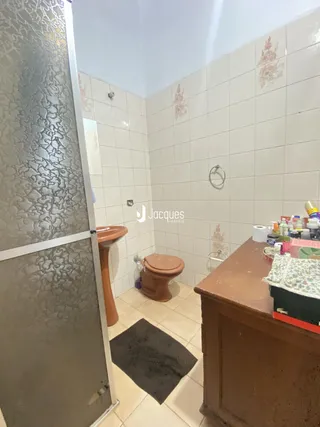 A foto mostra o interior de um banheiro com revestimento cerâmico nas paredes e piso.