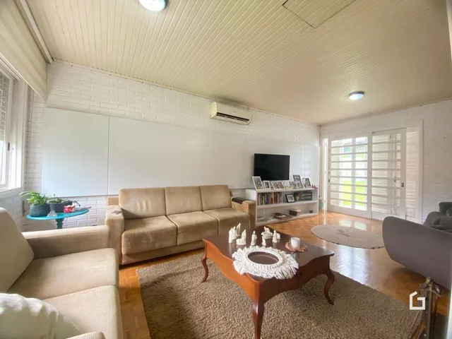 Sala de estar com sofá e piso de madeira clara em um imóvel no Brasil.