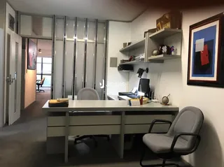 Foto de uma sala de estar interna com estantes e móveis.