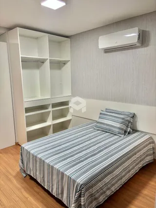 Quarto com armários embutidos e piso de madeira clara.
