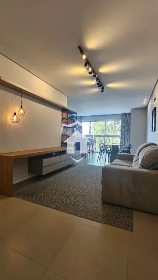Uma sala de estar com piso claro e iluminação embutida é visível na propriedade.