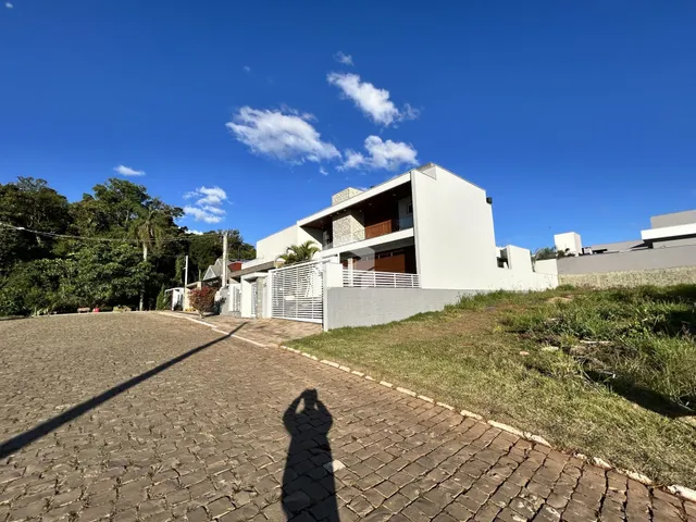 Fachada de uma casa moderna em Lajeado, Brasil, com jardim e entrada pavimentada.