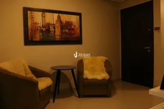 Sala de estar com duas poltronas e uma pintura na parede.