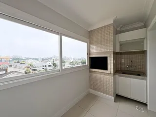 Interior de uma sala com grande janela de vista para a paisagem urbana.