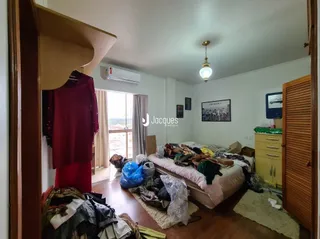 Quarto com roupas e cama visíveis no interior da propriedade.