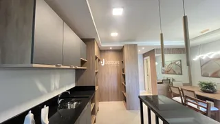 Vista da cozinha moderna com armários e bancada escura.