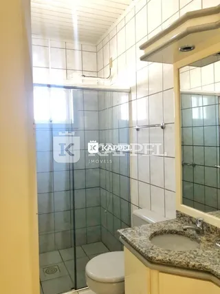 Foto de um banheiro com box de vidro e pia de granito.