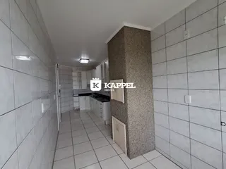 Corredor interno com piso e paredes brancas em um imóvel.