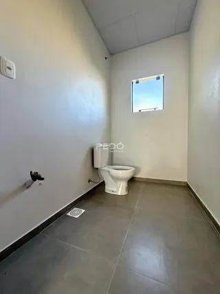 A foto mostra um banheiro com piso de cerâmica e paredes brancas.